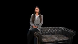 AI presenter Adriana, suit sofa